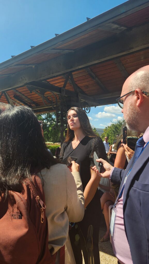 A reporter speaks with one of Epstein's victims at the press conference outside the Capitol.