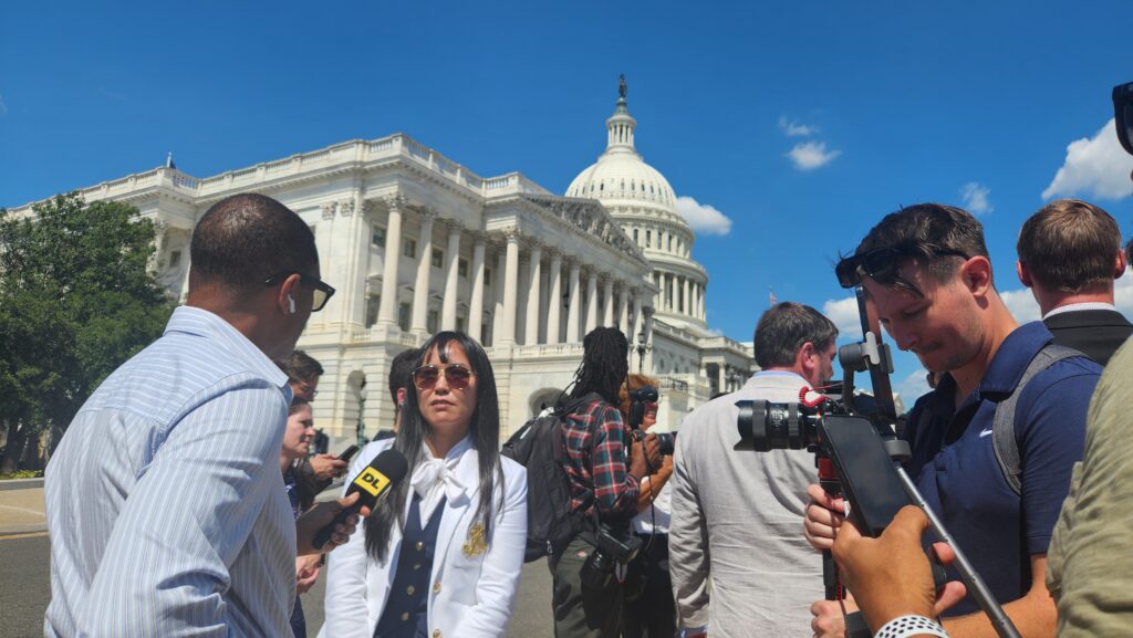 A reporter speaks with one of Epstein's victims at the press conference outside the Capitol.